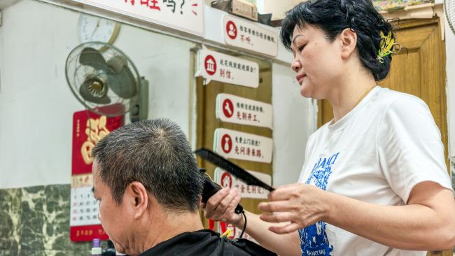韦素梅在为居民理发。李文博摄