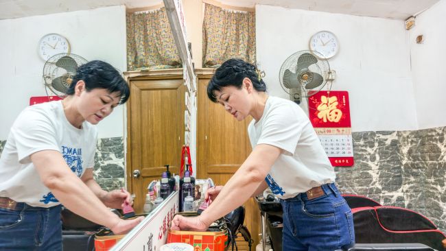 韦素梅在整理理发工具。李文博摄