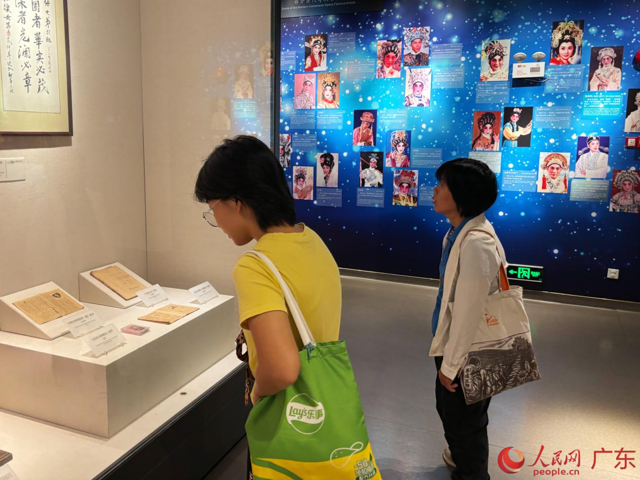 市民家长携孩子参观戏曲展馆，通过实物展品了解传统戏曲文化。人民网 李舜摄