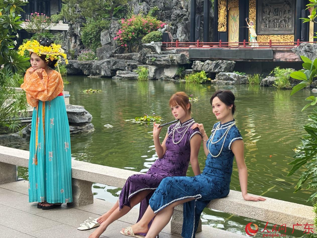 游客身着旗袍、传统汉服，在粤剧戏台前取景拍照。人民网 李舜摄