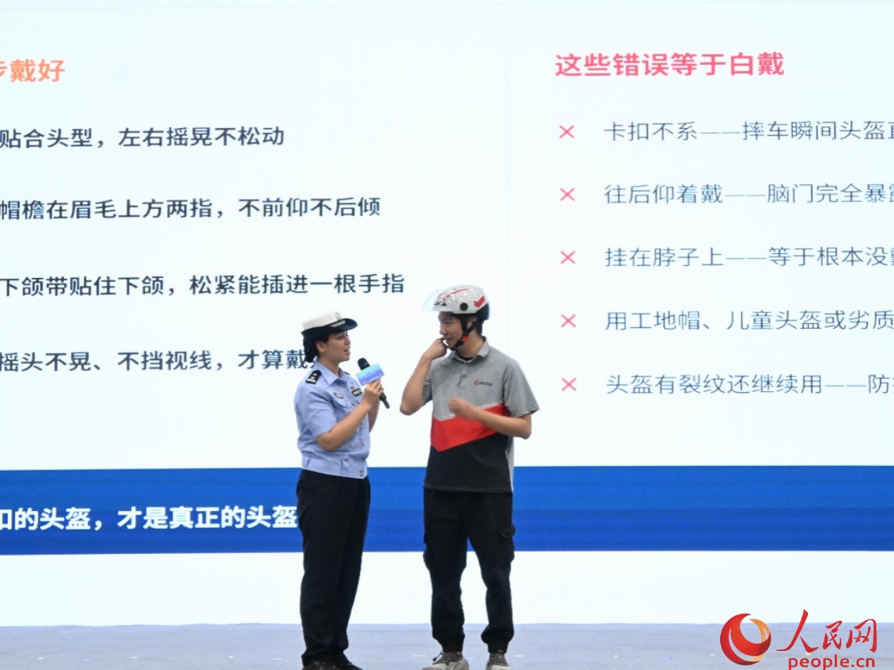 活动现场还举行文明安全骑行宣讲，骑手被邀请上台演示头盔正确的佩戴方式。人民网 李国华摄