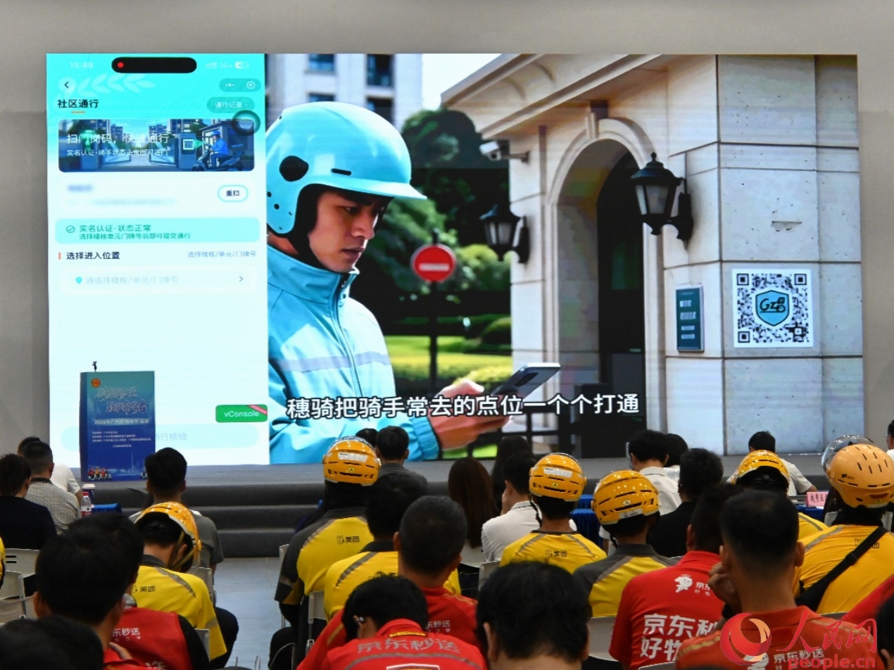 活动现场播放的“穗骑”平台宣传视频，向骑手们介绍了驿站查询、爱心餐预约、课程报名、诉求反馈等功能。人民网 李国华摄