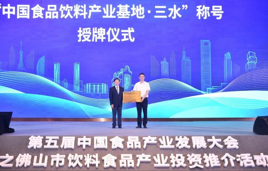 三水区区长黄海（右）从中国轻工业联合会会长张崇和手中接过“中国食品饮料产业基地·三水”牌匾