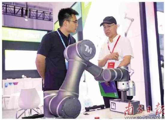 参展商达明机器人工作人员与采购商交谈。孙俊杰摄