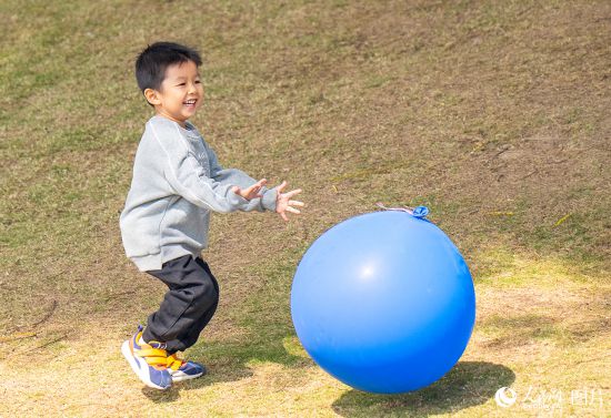 2024年12月22日，深圳市寶安濱海文化廣場，孩子在冬日陽光下開心的追逐氣球。人民網 王星攝